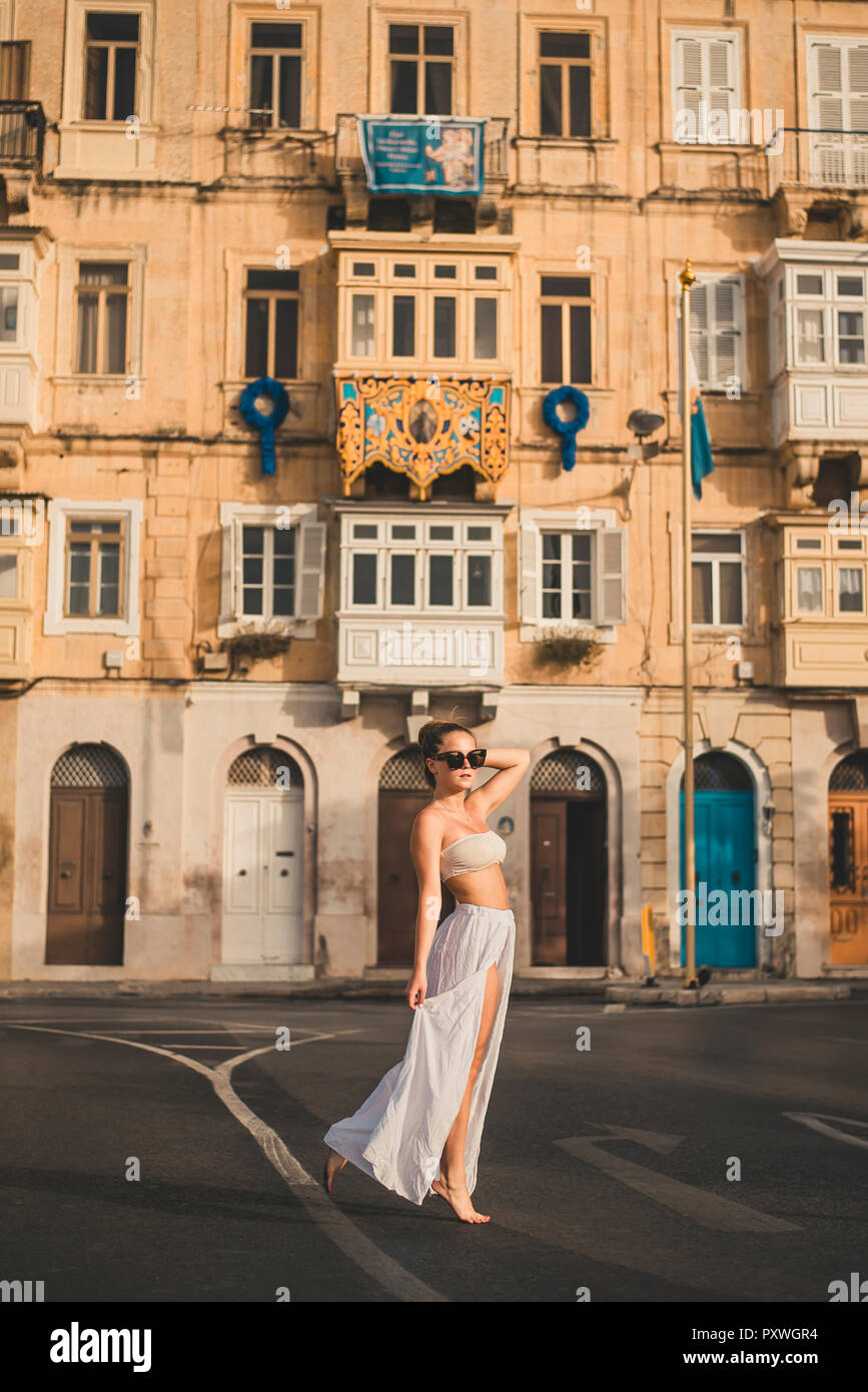 Ragazza adolescente weraing lunga gonna e top, ponendo in strada Foto Stock