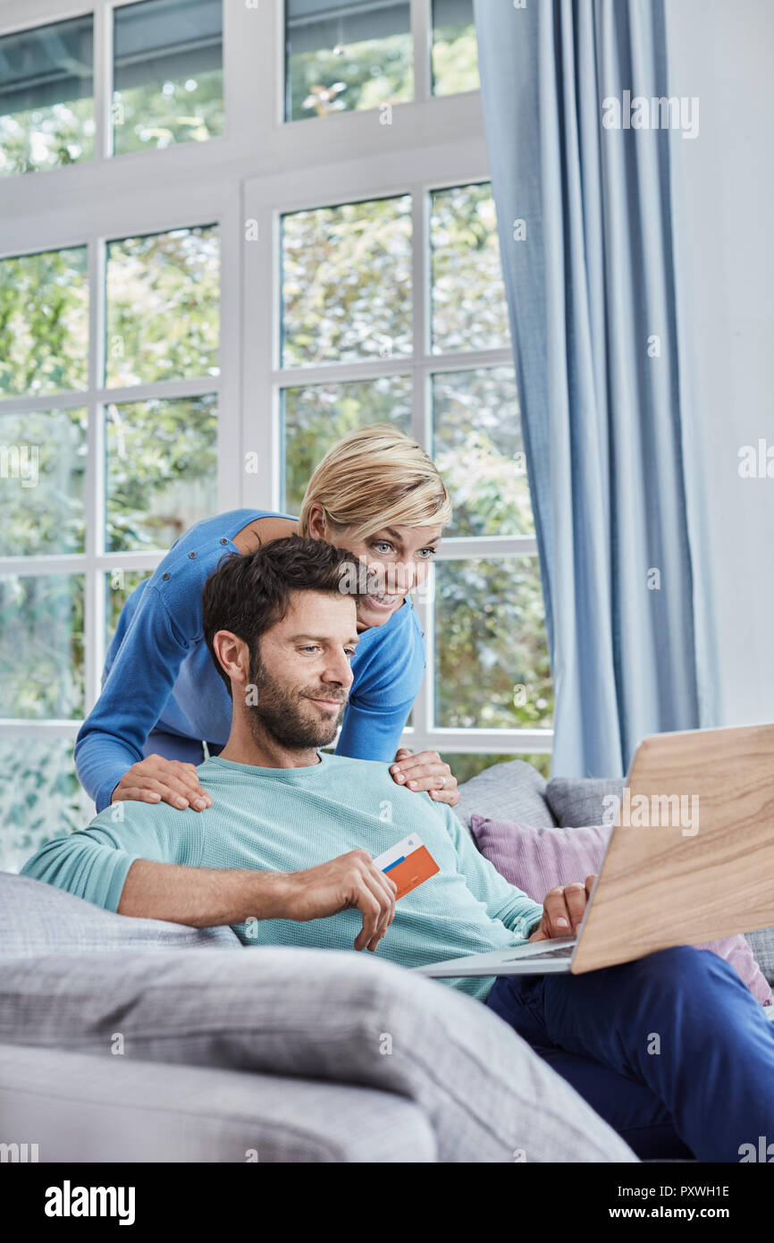 Coppia felice a casa lo shopping online Foto Stock