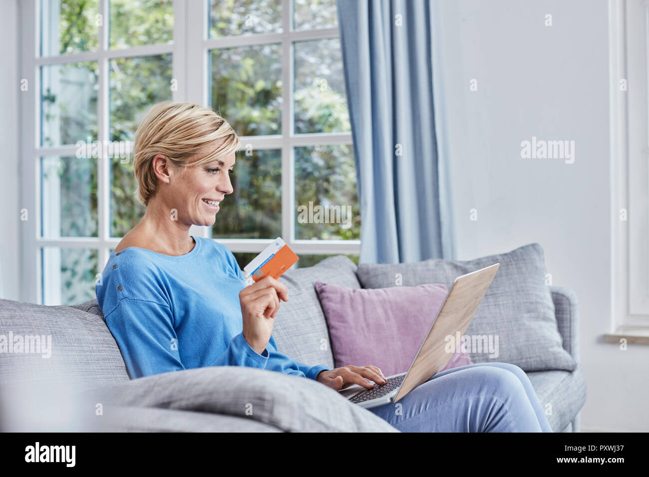 Donna felice a casa lo shopping online Foto Stock