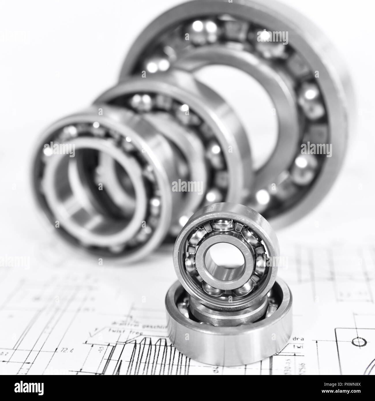 Controllo di qualità nella moderna ingegneria meccanica - Disegno tecnico e cuscinetti a sfera su sfondo bianco Foto Stock