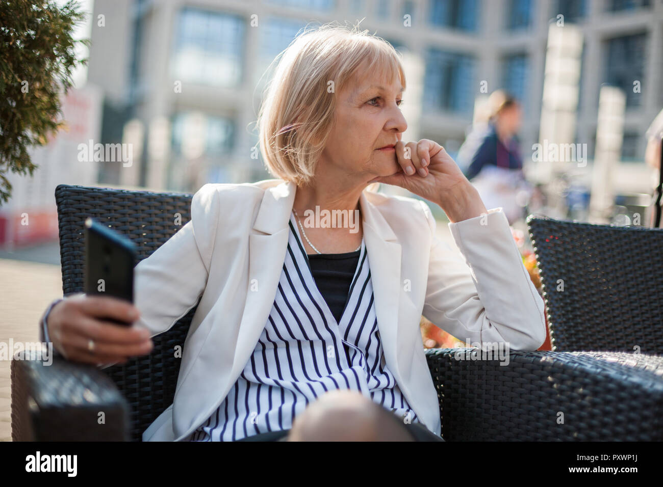 Preoccupato senior imprenditrice è seduta in cafe. Foto Stock