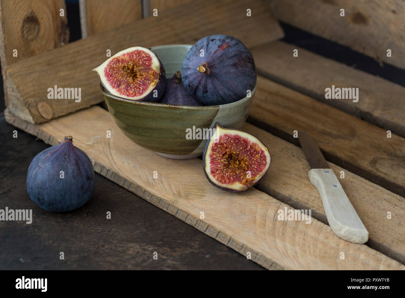 Affettato e intera fichi freschi, coltello da cucina e scatola di legno Foto Stock