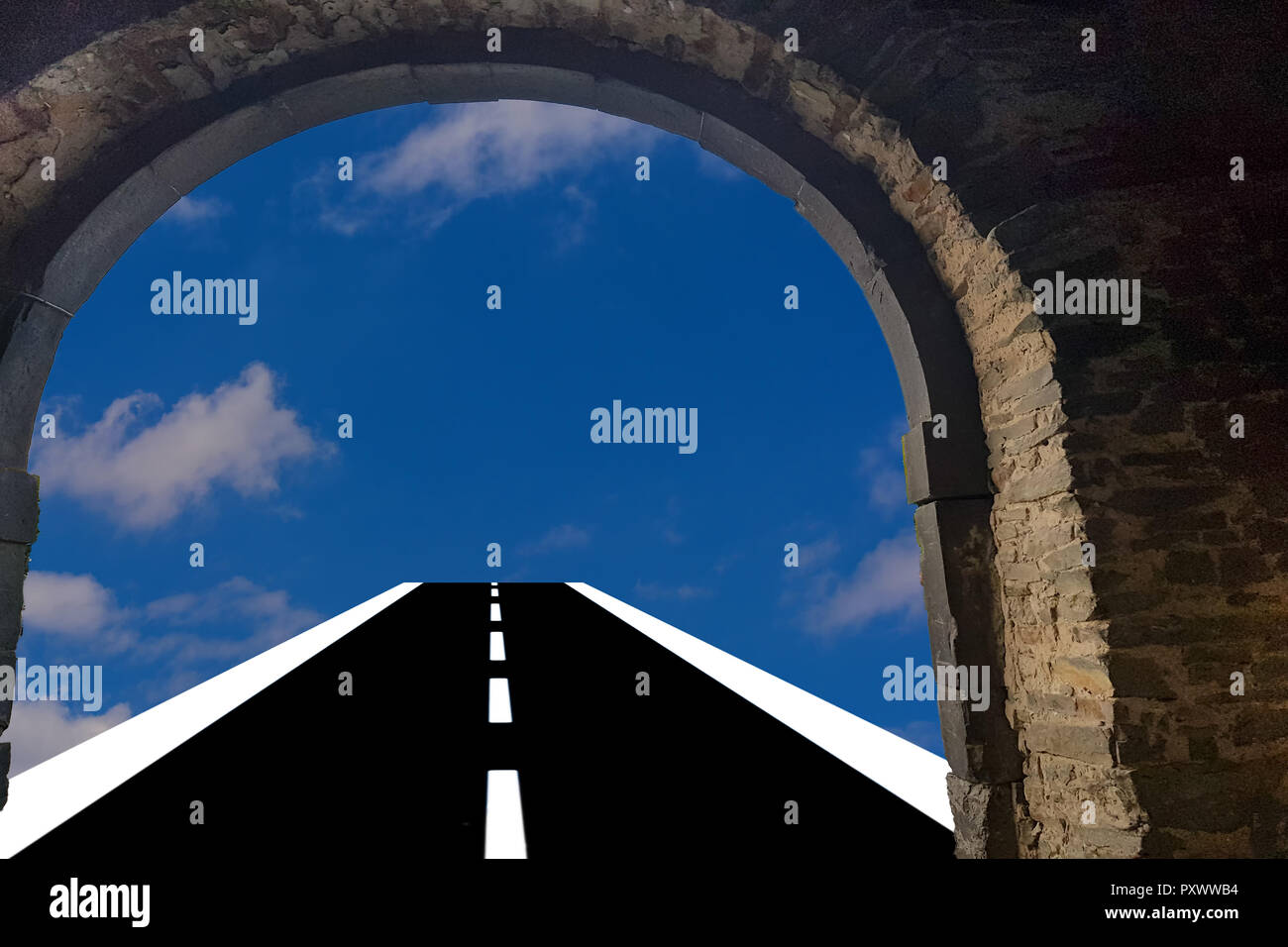Vista attraverso una porta arch. Strada asfaltata conduce nel blu cielo nuvoloso sfondo Foto Stock