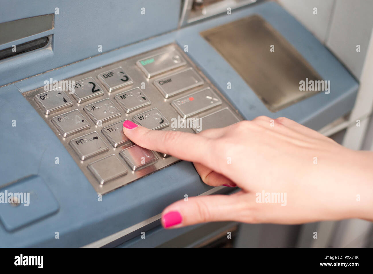 Dito che preme la password sul numero di bancomat Foto Stock