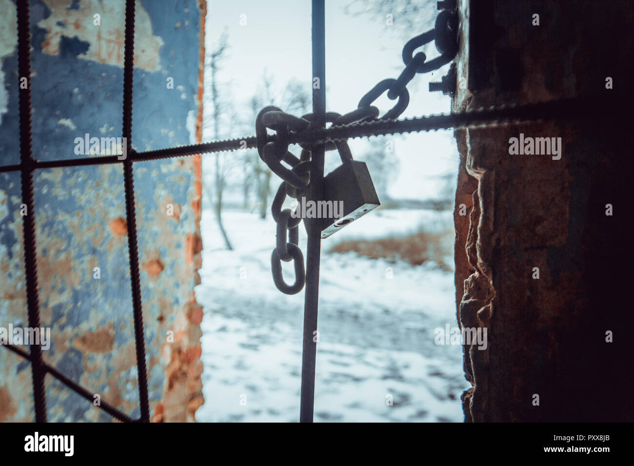 Il lucchetto e robusta catena in acciaio avvolto intorno ad aste metalliche sulla finestra Foto Stock