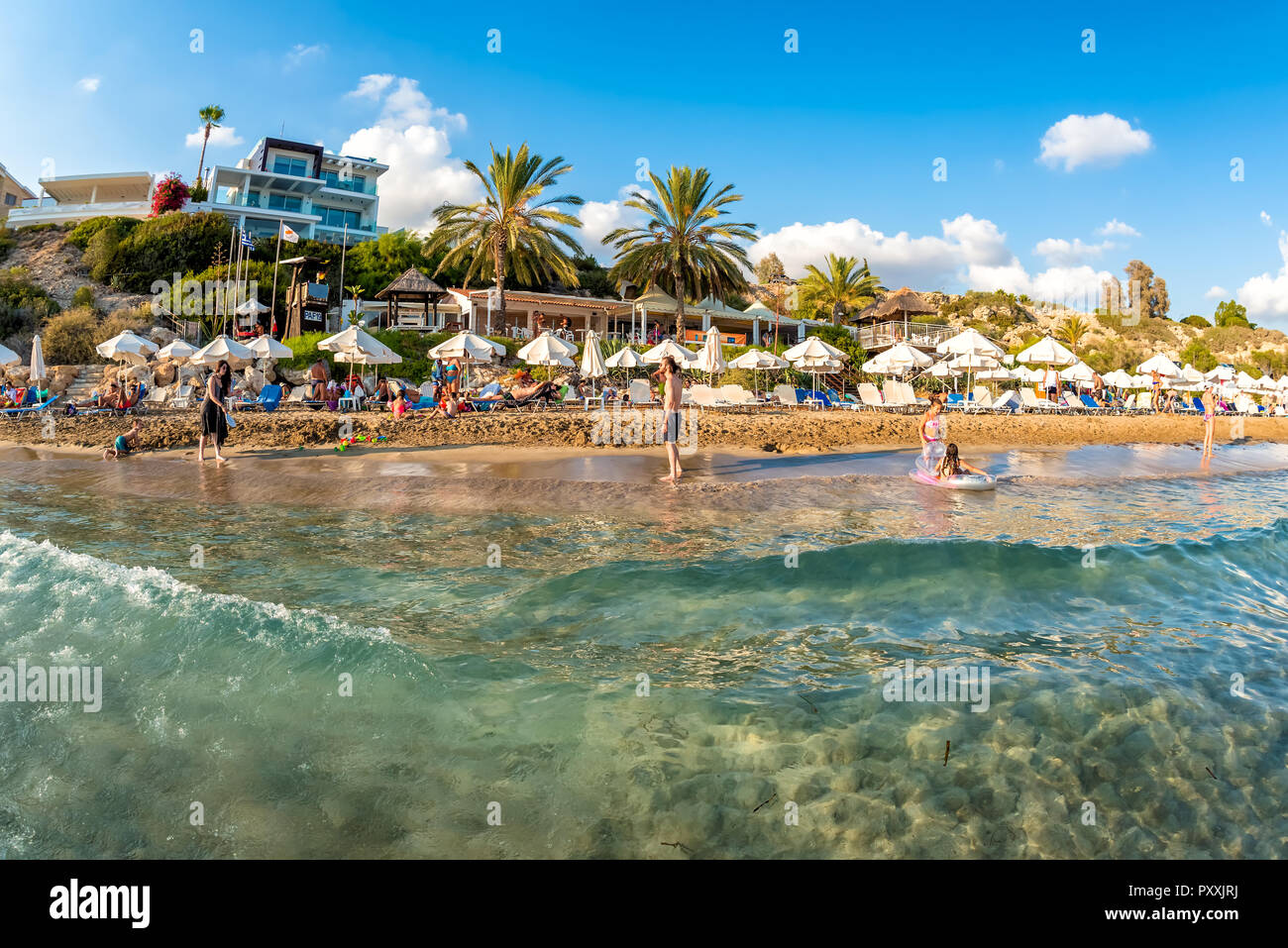 PAPHOS, Cipro - 20 agosto 2017: la gente in un momento di relax a Coral Bay Beach una delle più famose spiagge di Cipro. Foto Stock