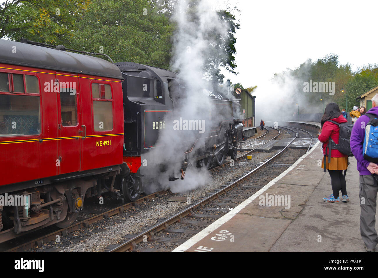 BR Standard Classe 4 2-6-4 serbatoio del motore in partenza con il suo treno di Gresley C Mk 1 carrelli da Pickering stazione sul patrimonio NYMR ferrovia. Foto Stock