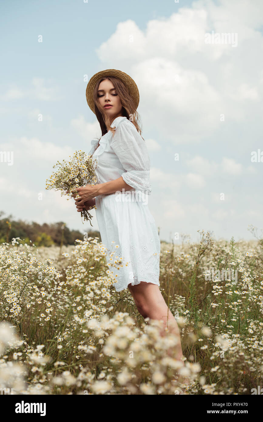 Pretty Woman in abito bianco con bouquet di wild camomilla fiori sul prato  Foto stock - Alamy