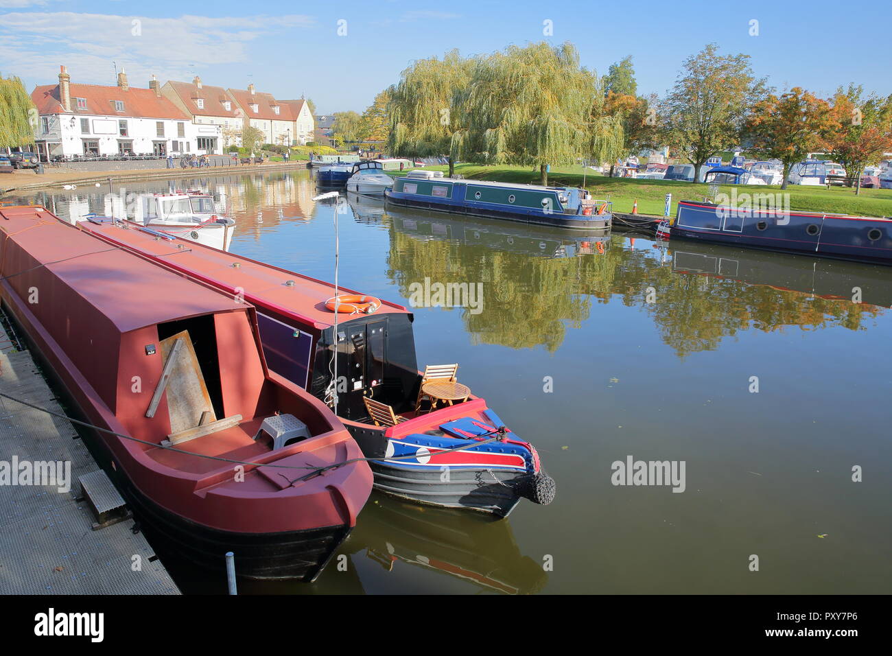 Il Riverside in autunno con chiatte ormeggiate sul grande fiume Ouse e case tradizionali, Ely, Cambridgeshire, Norfolk, Regno Unito Foto Stock
