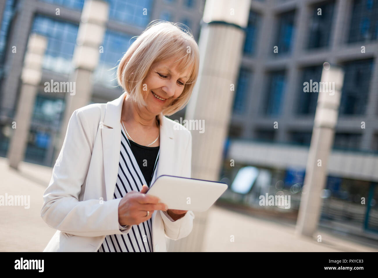 Outdoor ritratto di felice senior imprenditrice che utilizzano la tavoletta digitale. Foto Stock