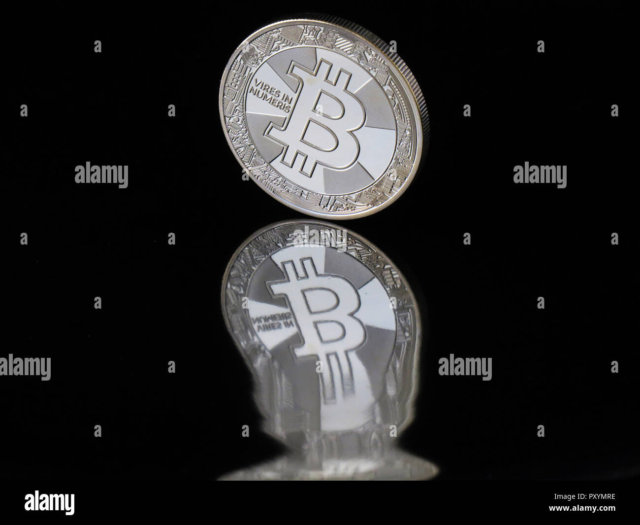 Berlino, Germania. Il 30 agosto, 2018. Il 30 agosto 2018, Germania Berlino: una moneta Bitcoin con l impronta "eccesso di potere in Numeris' (forza in numeri) riflette distorta in un'area nera. La valuta digitale è stata intorno per dieci anni e ora è basato su blockchains (catene di blocchi di dati in cui le unità di Bitcoin sono generati in operazioni matematiche su computer. Credito: Soeren Stache/dpa-Zentralbild/ZB/dpa/Alamy Live News Foto Stock