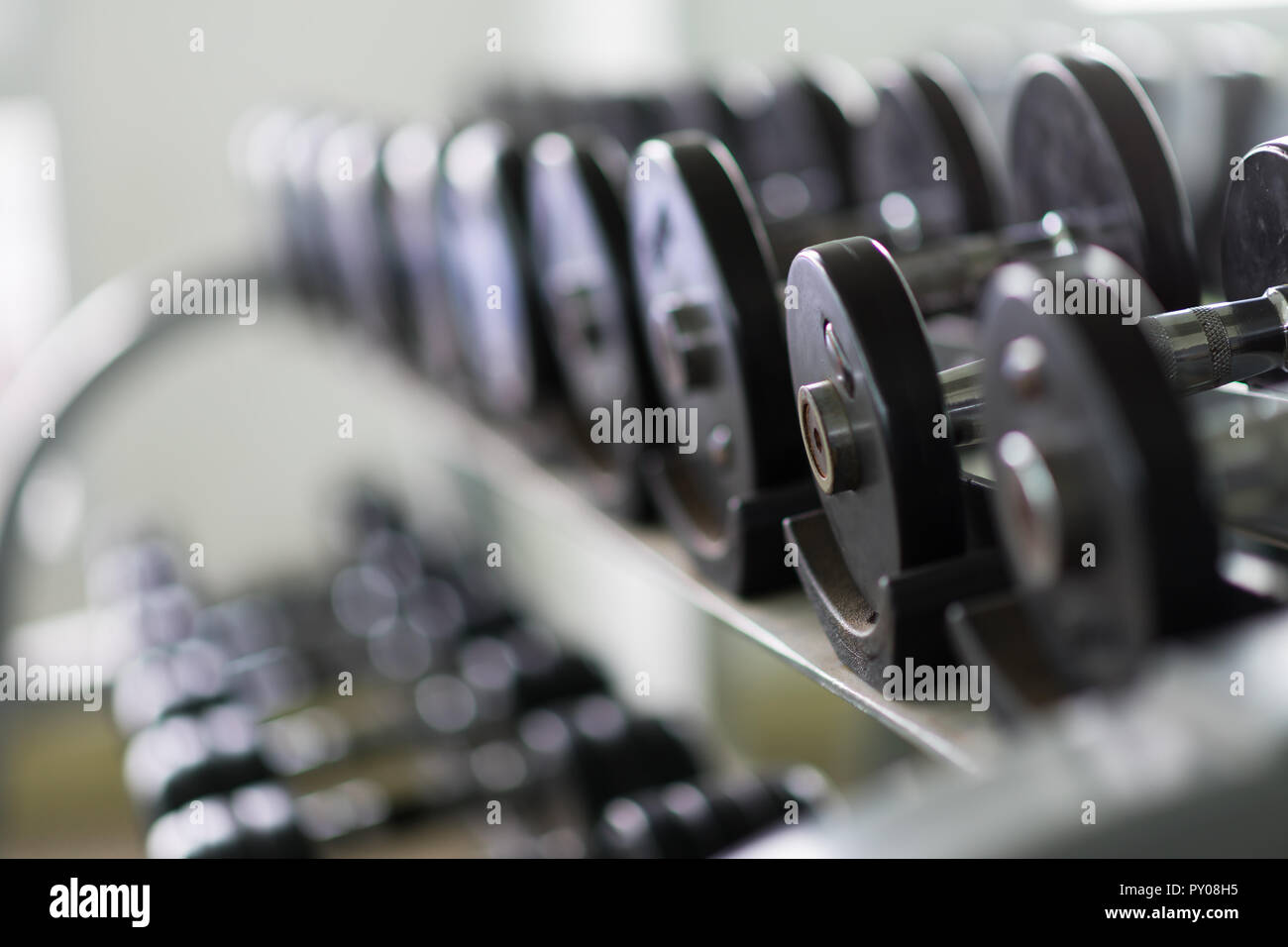 Righe di metallo manubri su rack in palestra / sport club. Peso attrezzatura di formazione. Foto Stock