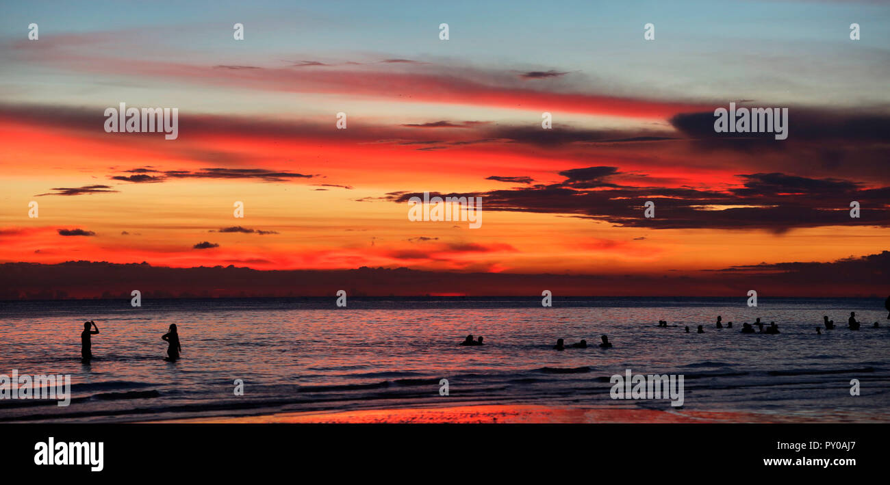Sagome di turisti nuotare nel mare al tramonto, Boracay, Aklan, Filippine Foto Stock