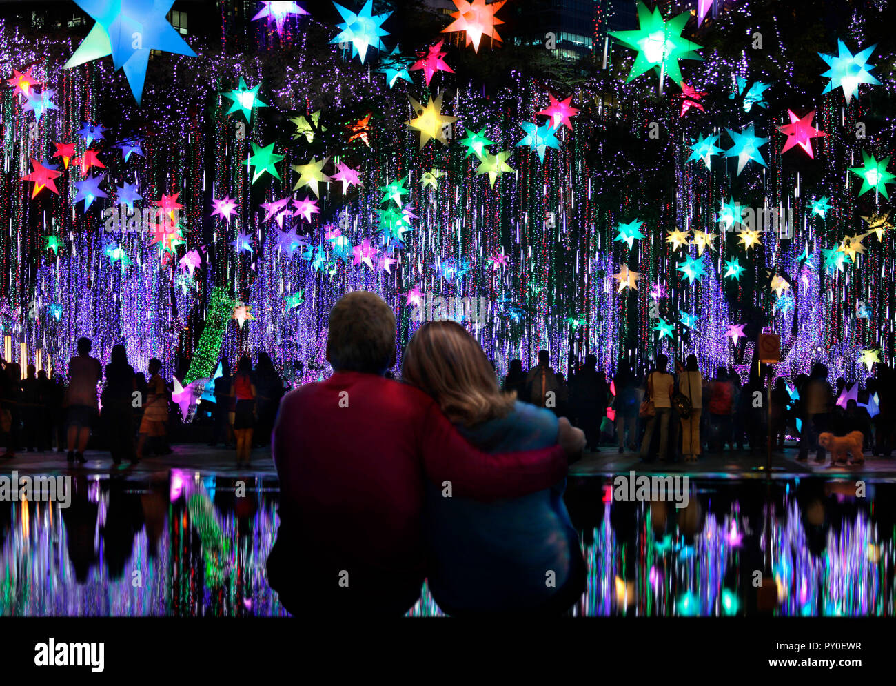 Coccolatevi con una coppia che guarda lo spettacolo di luci natalizie all'Ayala Triangle Gardens, Makati, Manila, Filippine Foto Stock