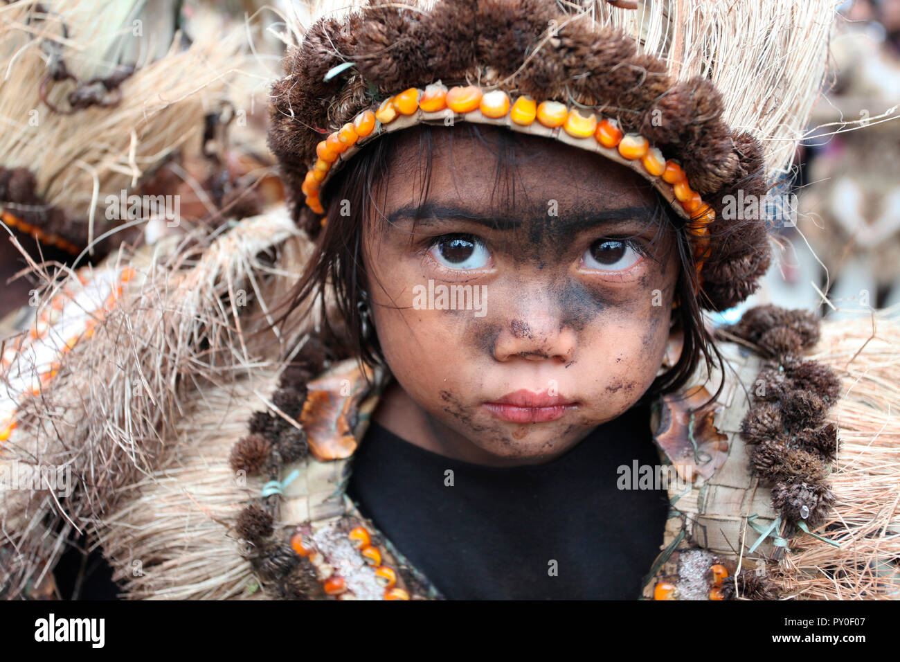 Bellissima bambina con il nero cosparso facce indossando il costume tribale in Ati Atihan festival, Kalibo, Aklan, Panay Island, Filippine Foto Stock