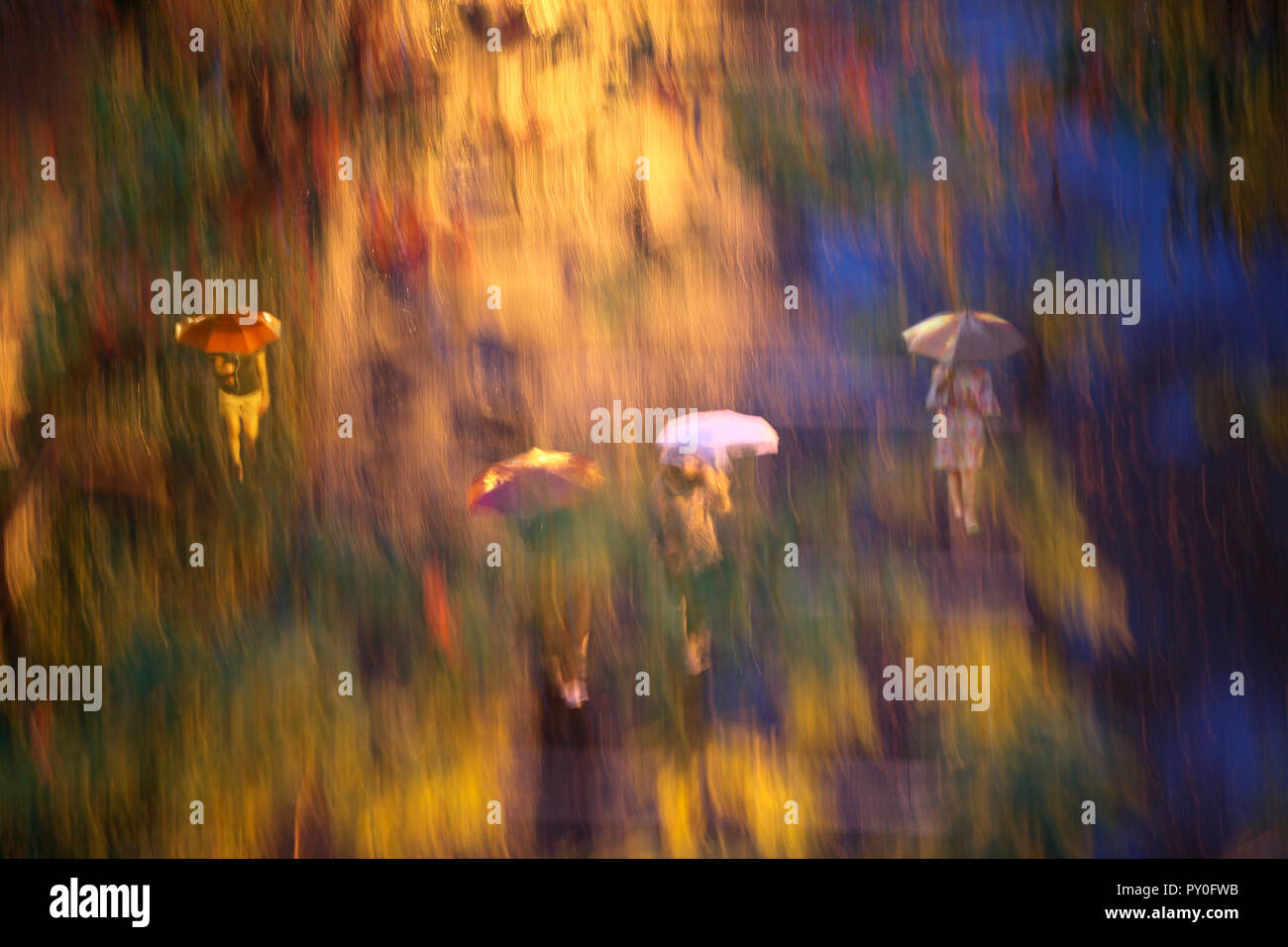 Immagine sfocata di persone a piedi sotto la pioggia nel Central Park di New York City, New York, Stati Uniti d'America Foto Stock