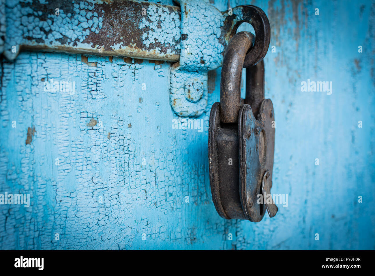 Rusty grunge lucchetto sul vecchio legno blu sullo sfondo della parete Foto Stock