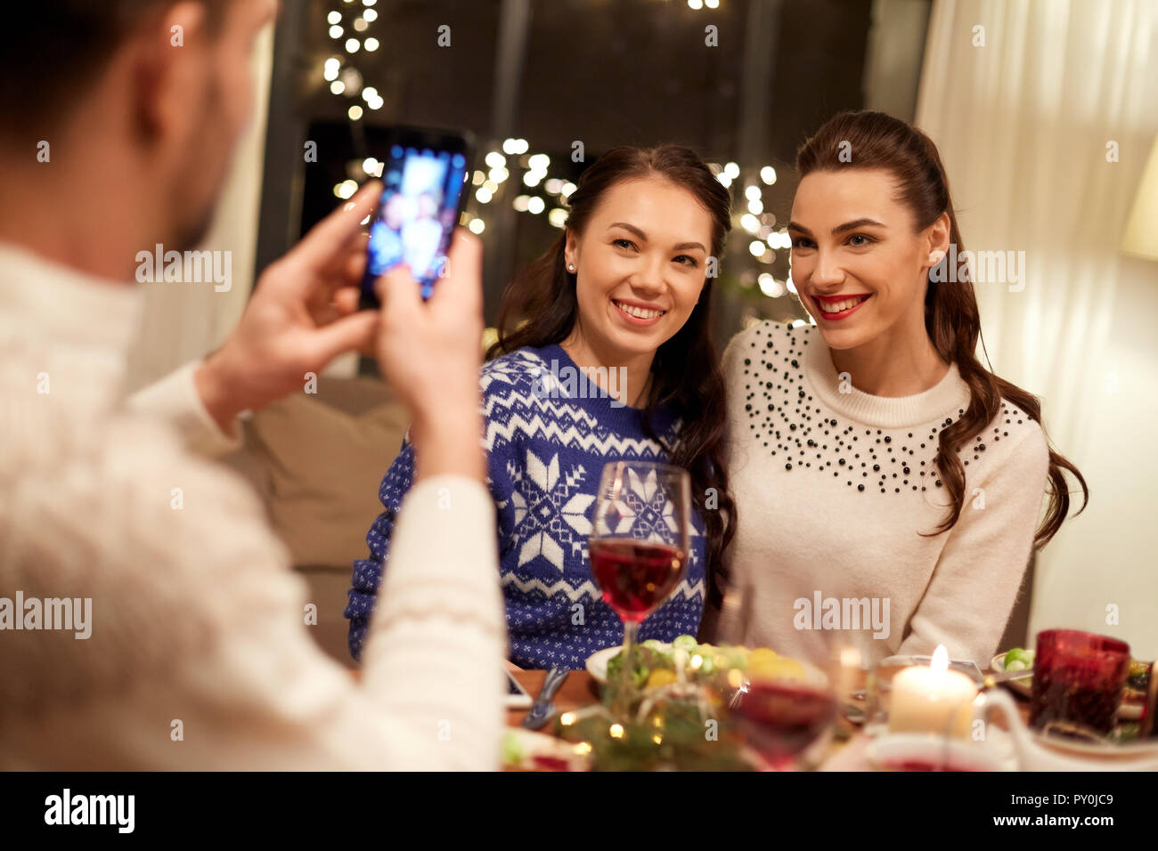 Amici avente la cena di natale e di scattare una foto Foto Stock