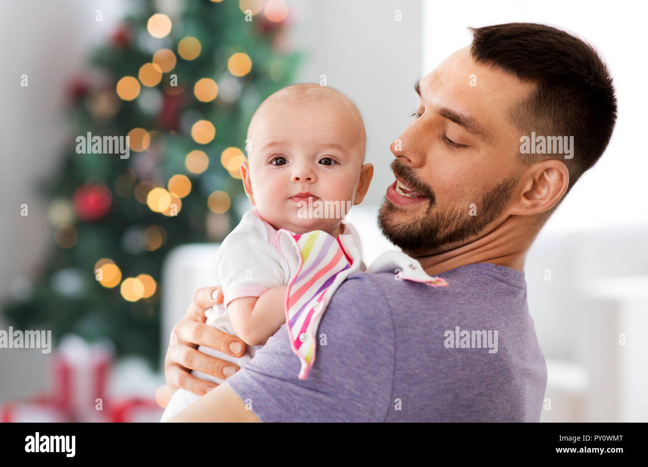 Padre con la nostra bambina su albero di natale Foto Stock