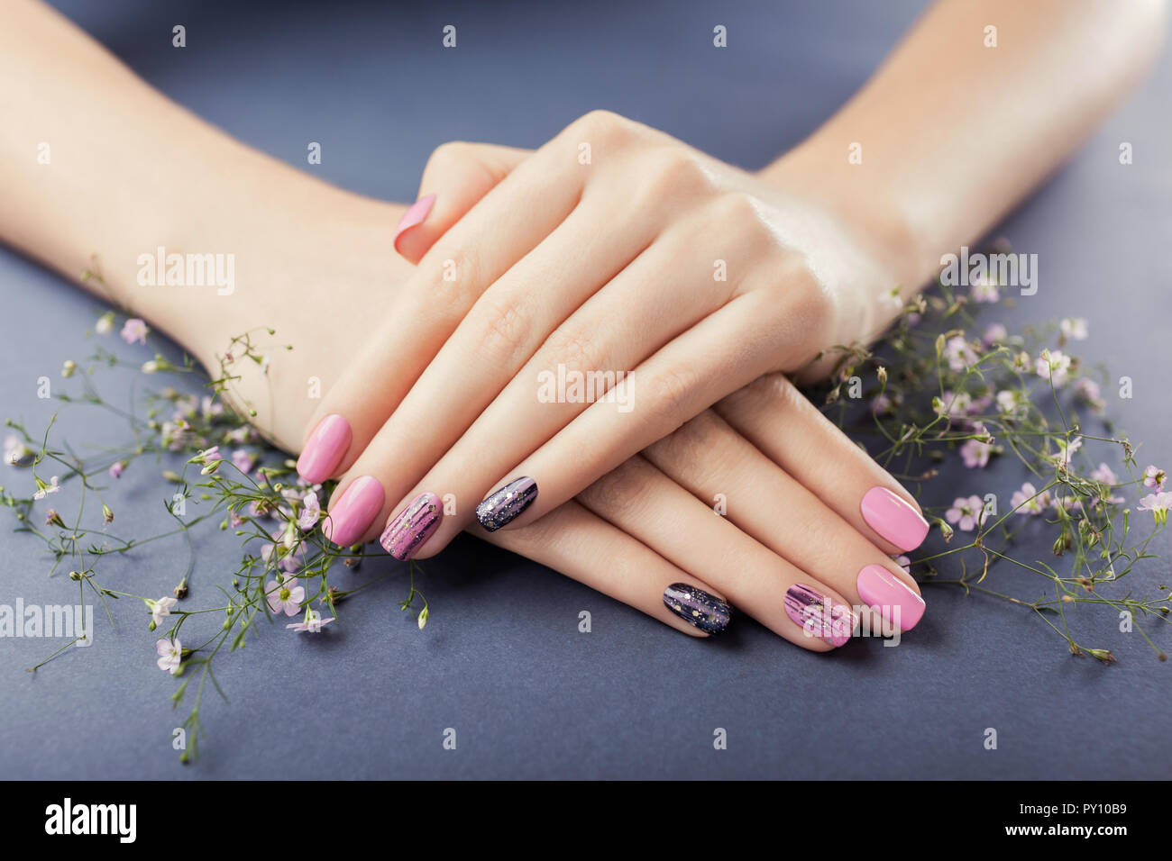Rosa e nero manicure con fiori su sfondo grigio. Nail art. Cura del corpo  Foto stock - Alamy