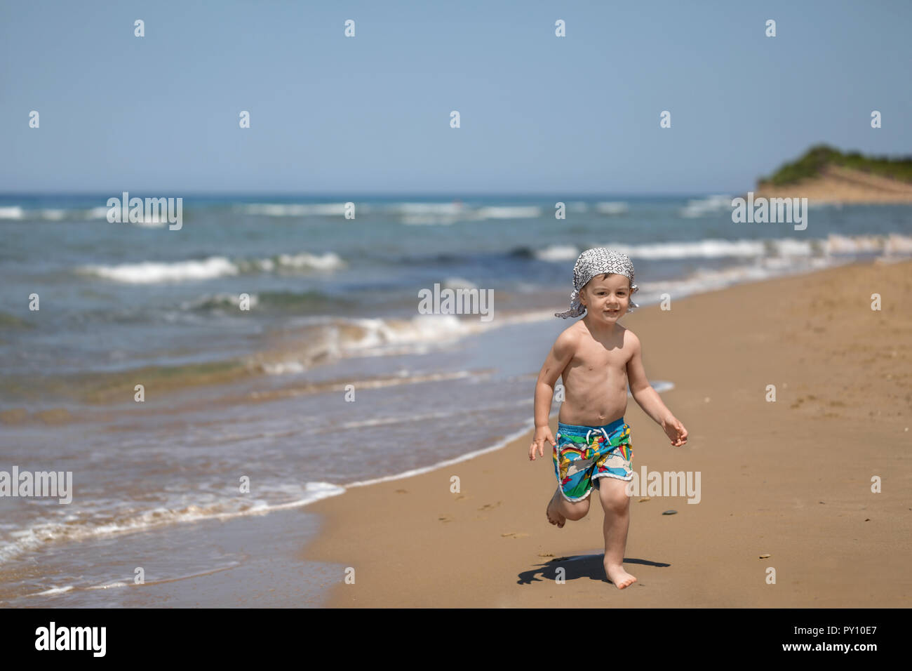 Ragazzo correre sulla spiaggia, Corfù, Grecia Foto Stock