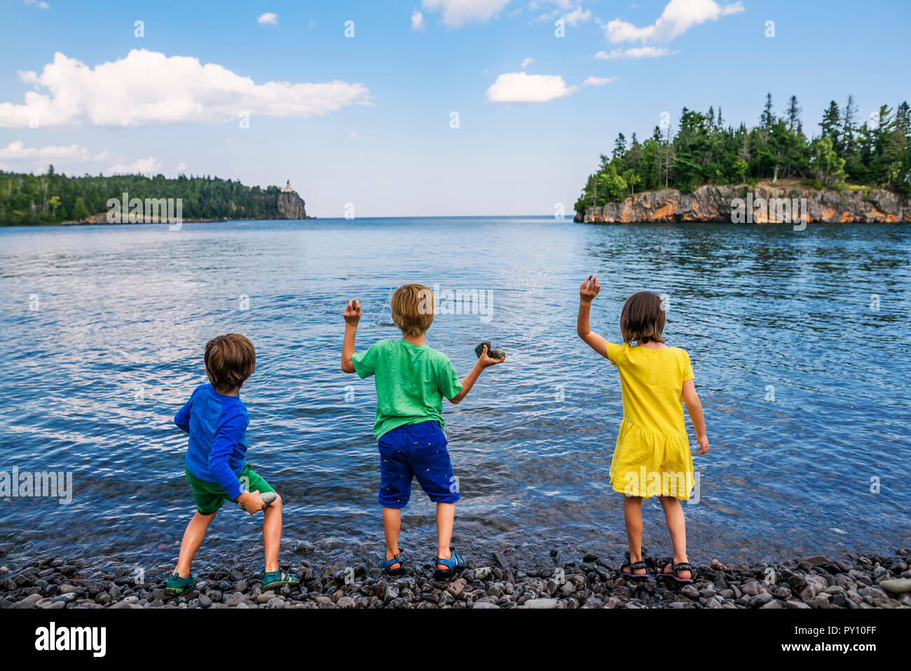Tre bambini gettando le rocce in un lago, Split Faro Rock State Park, Minnesota, Stati Uniti Foto Stock