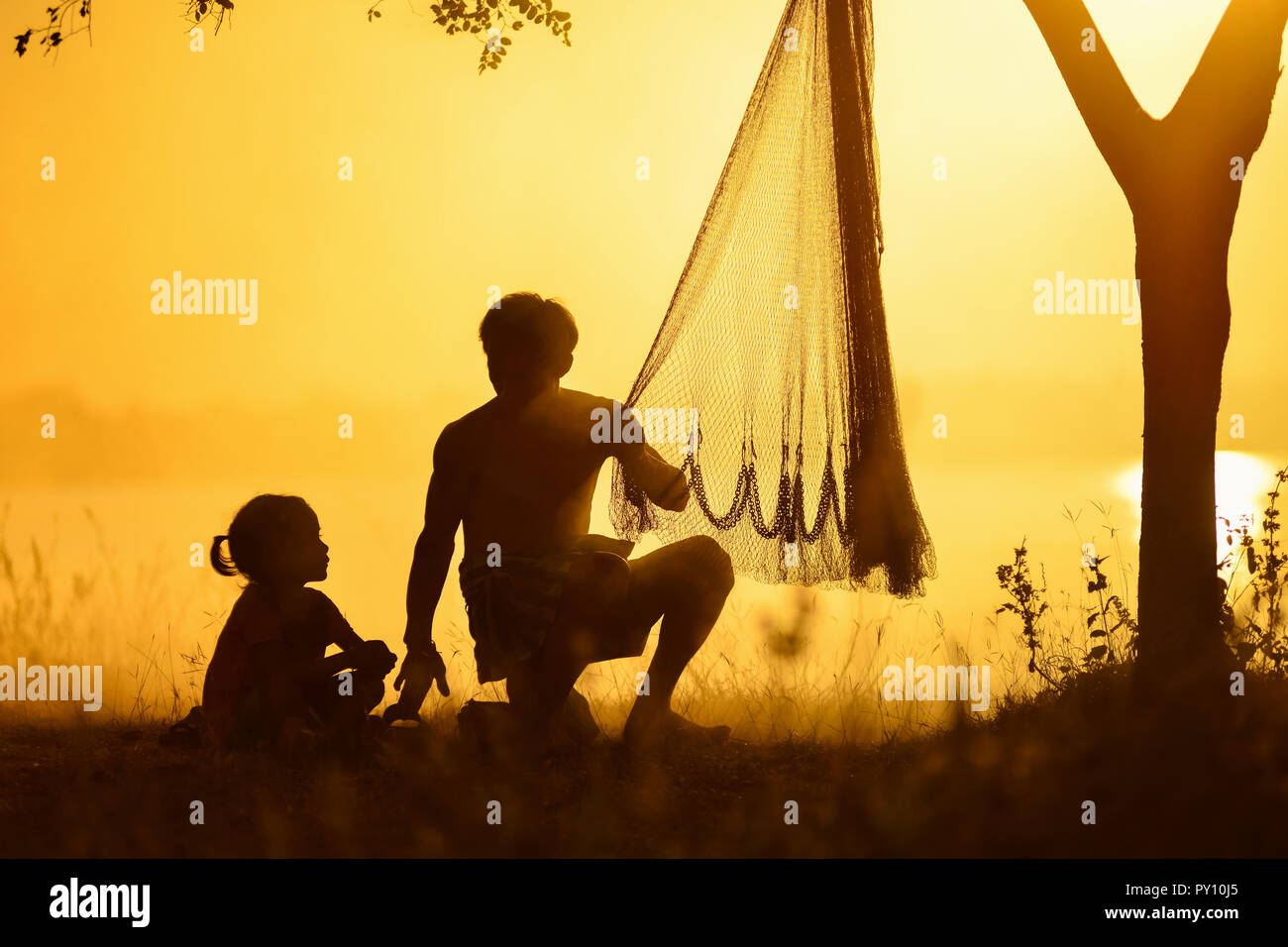 Silhouette di un padre e figlia al tramonto, Thailandia Foto Stock