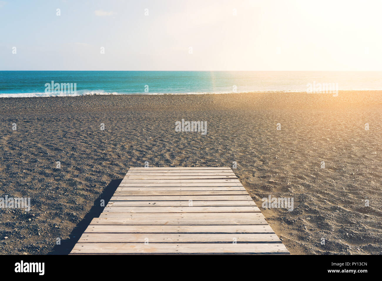 Gangplank in legno sulla spiaggia contro il mare e il cielo blu Foto Stock