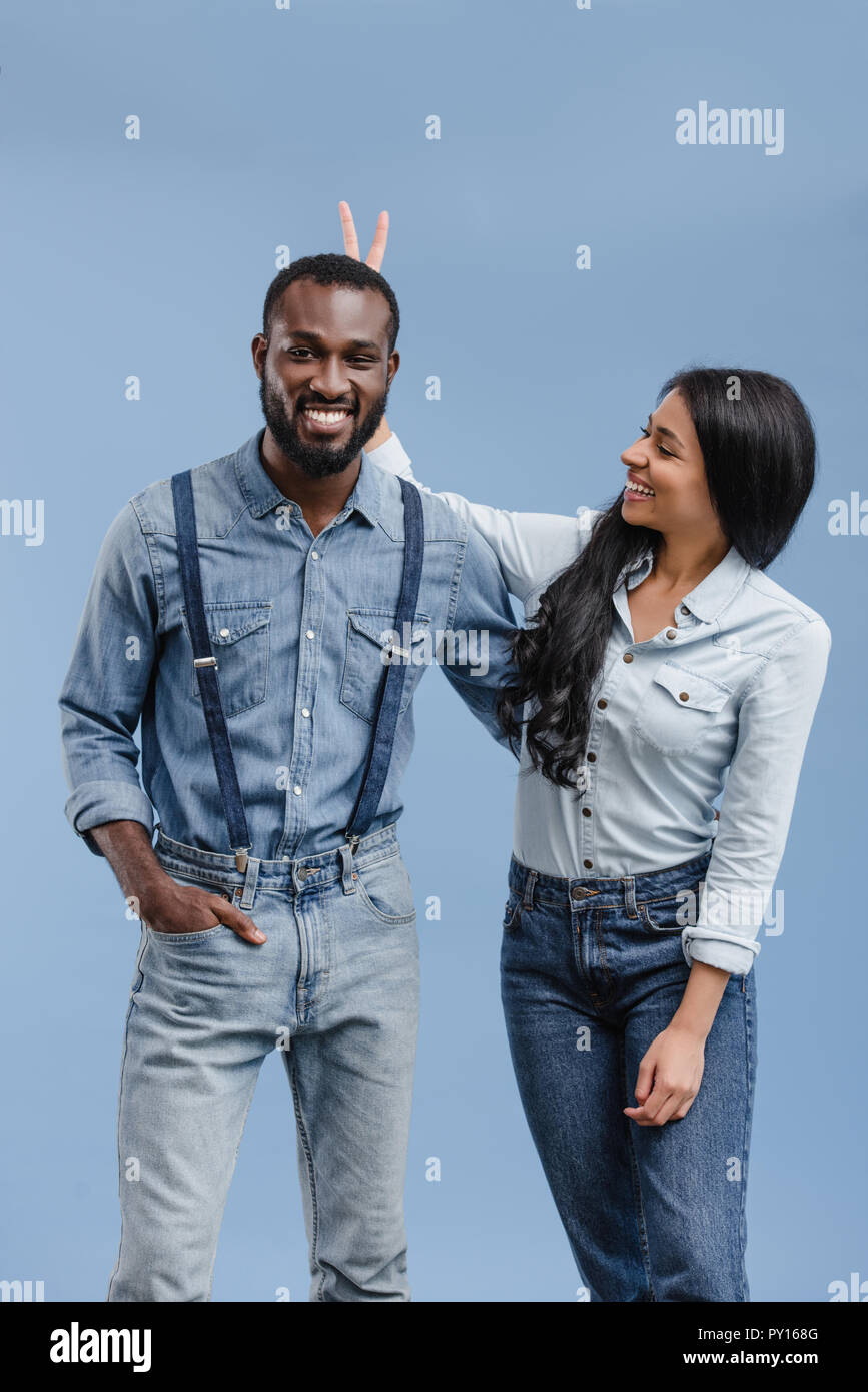 Sorridente americano africano ragazza che mostra due dita sopra il mio ragazzo isolato di testa su blu Foto Stock