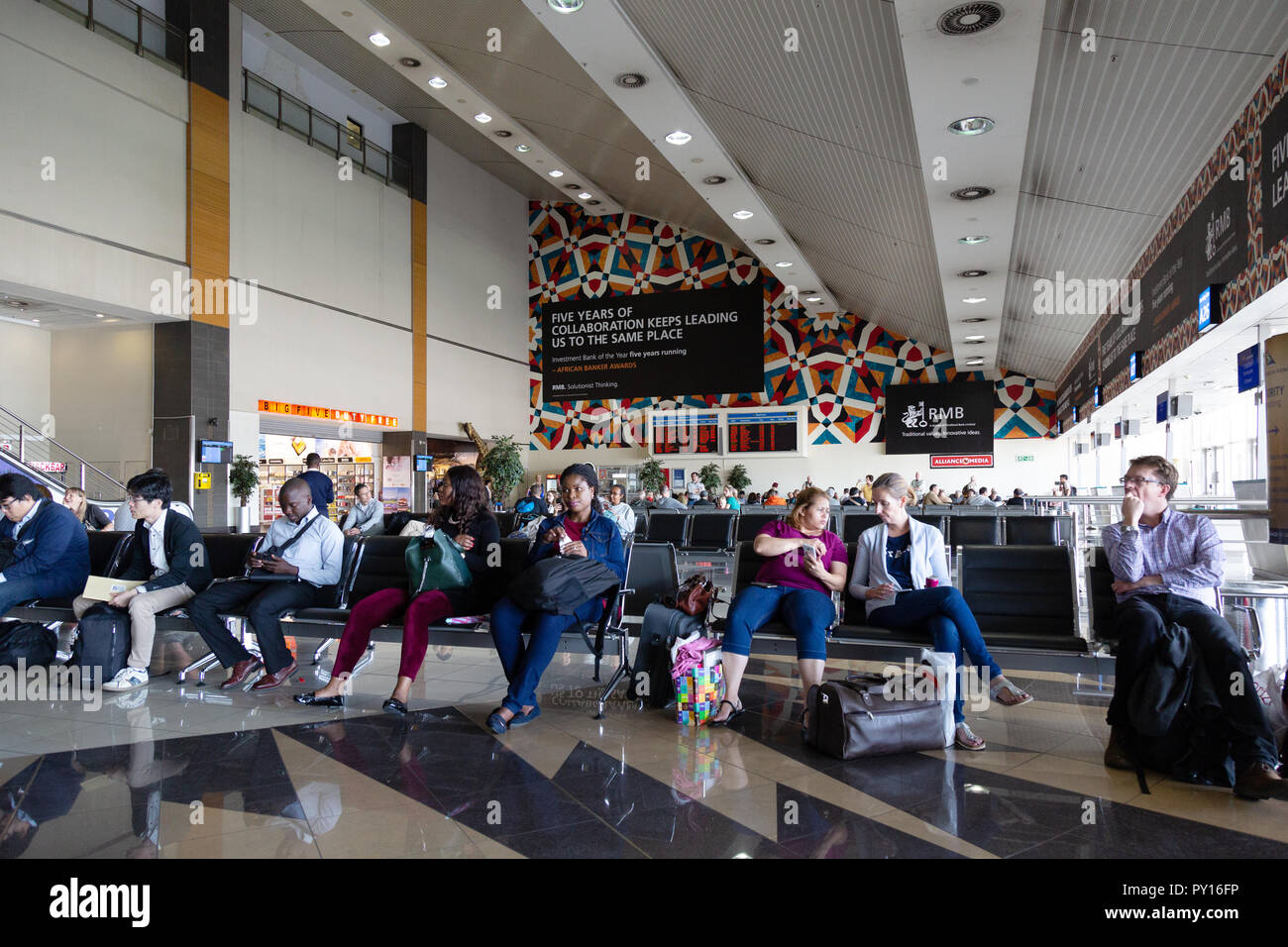 I passeggeri in attesa al gate, O.R.Tambo aeroporto, Johannesburg Sudafrica Foto Stock