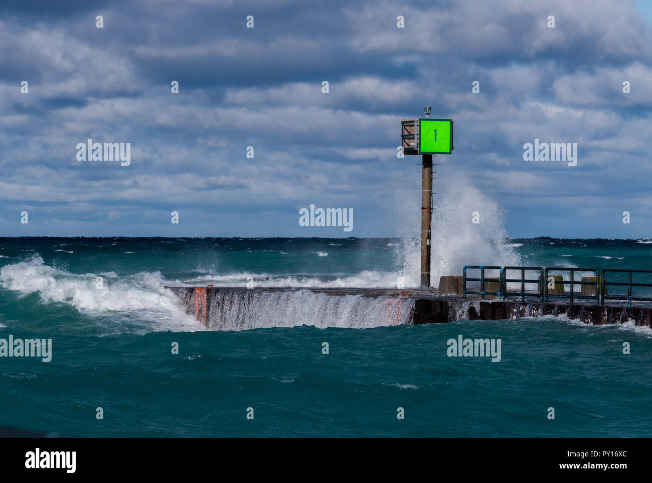 Onde che si infrangono sul marcatore #1 sul molo in Charlevoix, Michigan, Stati Uniti d'America. Foto Stock