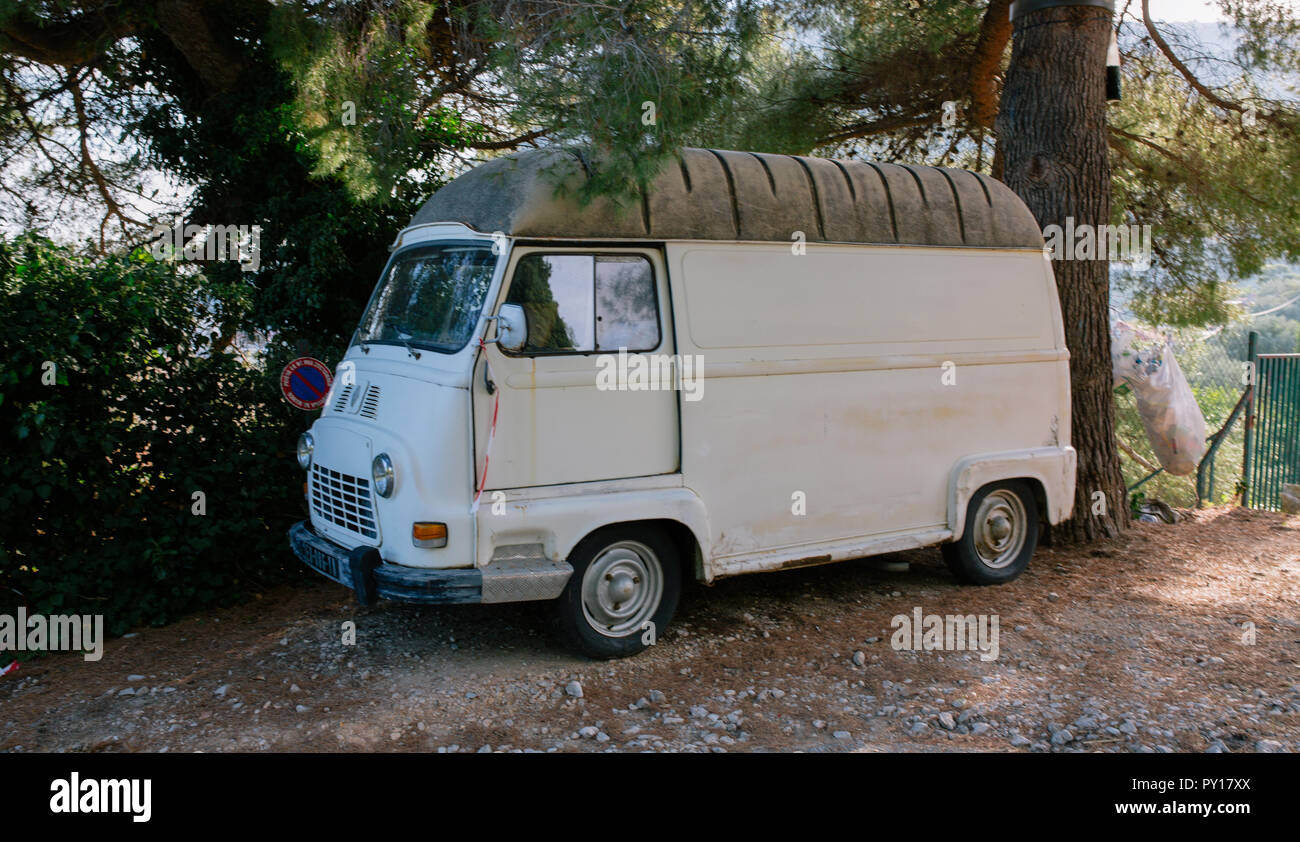 Vintage White Furgone Minibus su una strada di ghiaia sotto un albero Foto Stock