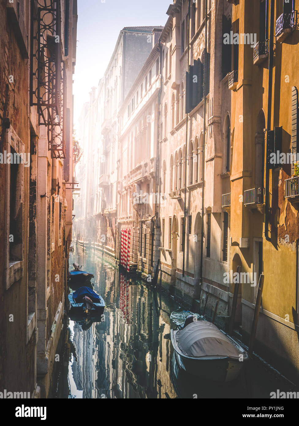 Mattina calda a Venezia, sun avvicinando lo stretto canale di acqua Foto Stock