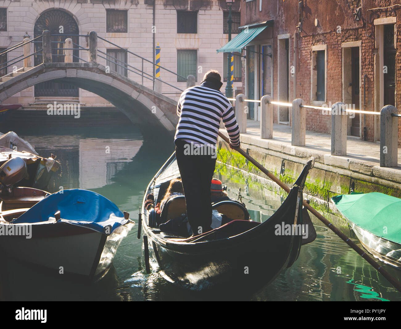 Giovane godendo di fare un giro in gondola nel canale d'acqua di Venezia Foto Stock