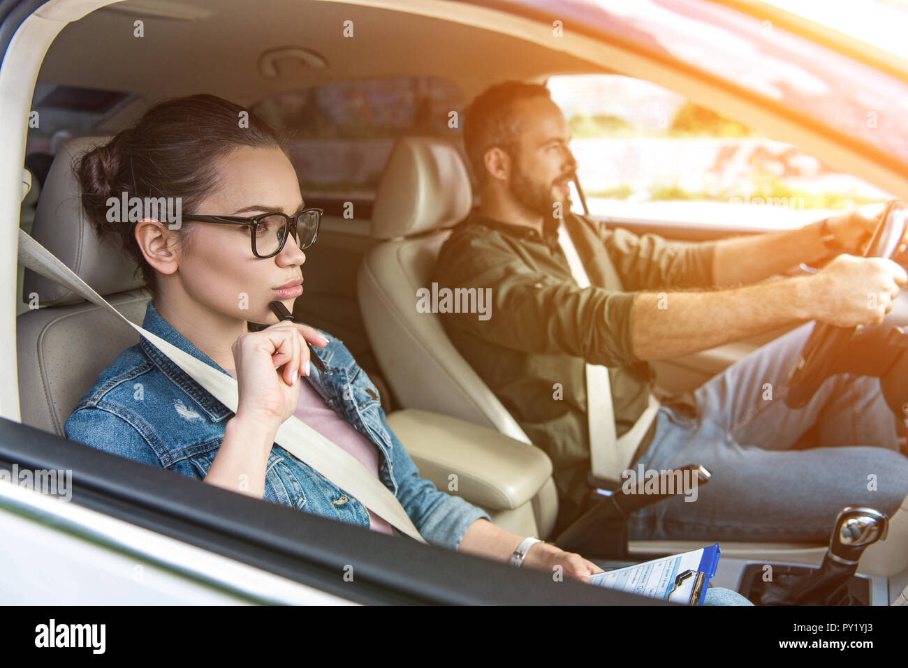 Studente maschio e femmina insegnante guida in auto alla guida di prova Foto Stock