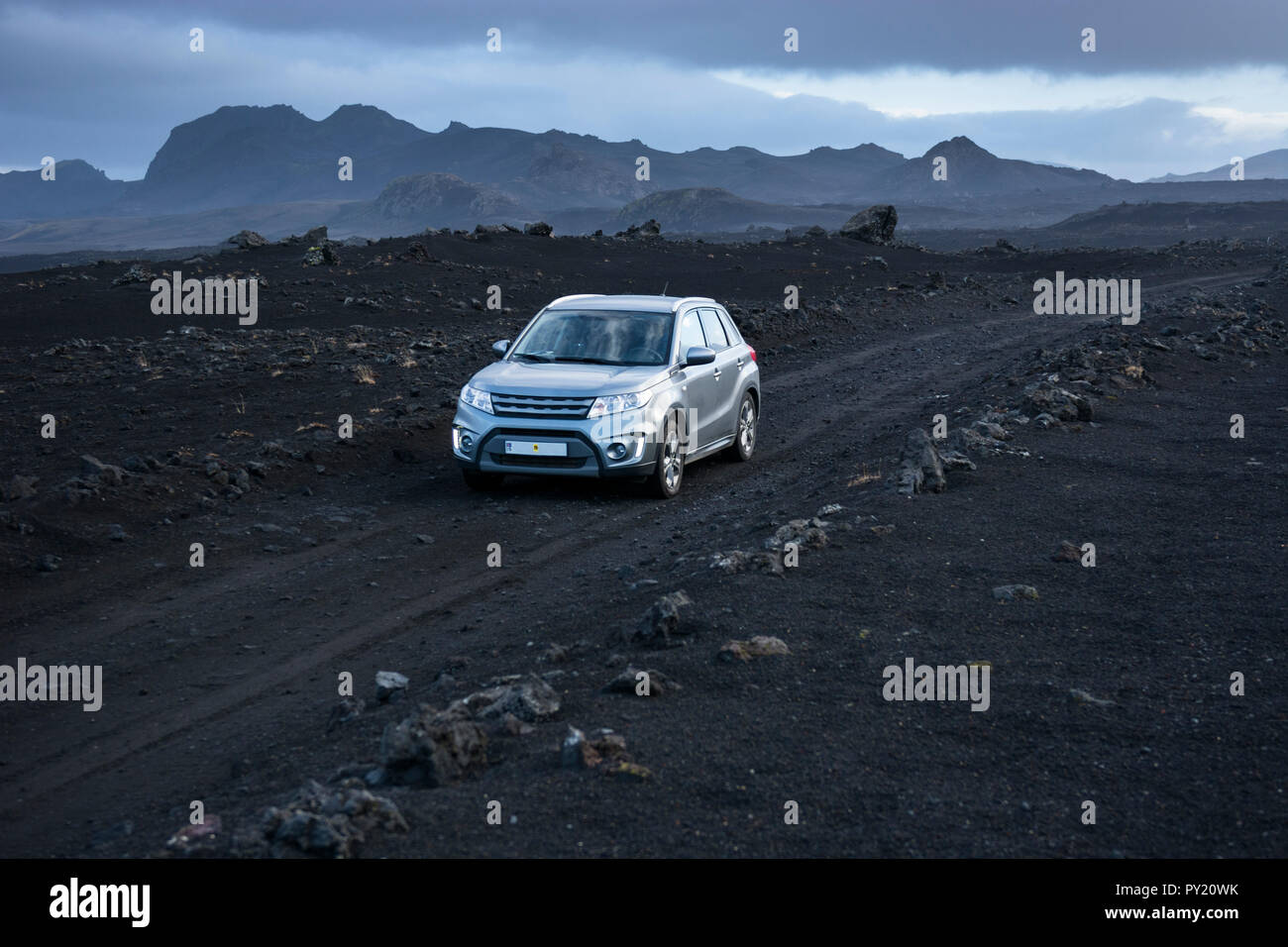 In color argento 4x4 SUV guidando lungo la strada sterrata nel paesaggio vulcanico, Sprengisandsleid, Islanda Foto Stock