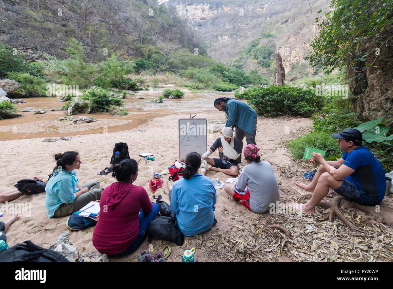 Bendaggio triangolare sling spiegazione durante un deserto first responder corso WFR, El Aguacero cascata, Chiapas, Messico Foto Stock