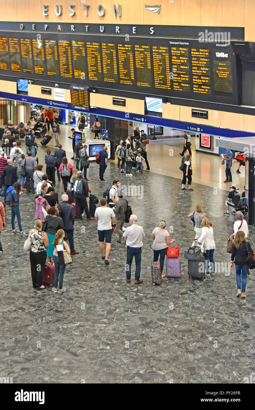 Vista da sopra guardando giù all interno della stazione dei treni di Euston concourse con passeggeri visualizzazione treno partenze Informazioni di viaggio Londra REGNO UNITO Foto Stock