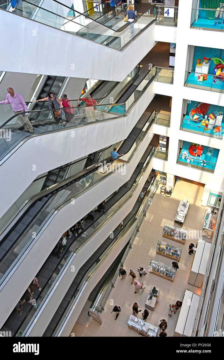 John Lewis e partner Oxford Street interno di department store con i clienti su scala mobile ai piani alti con vista giù al piano terra London REGNO UNITO Foto Stock