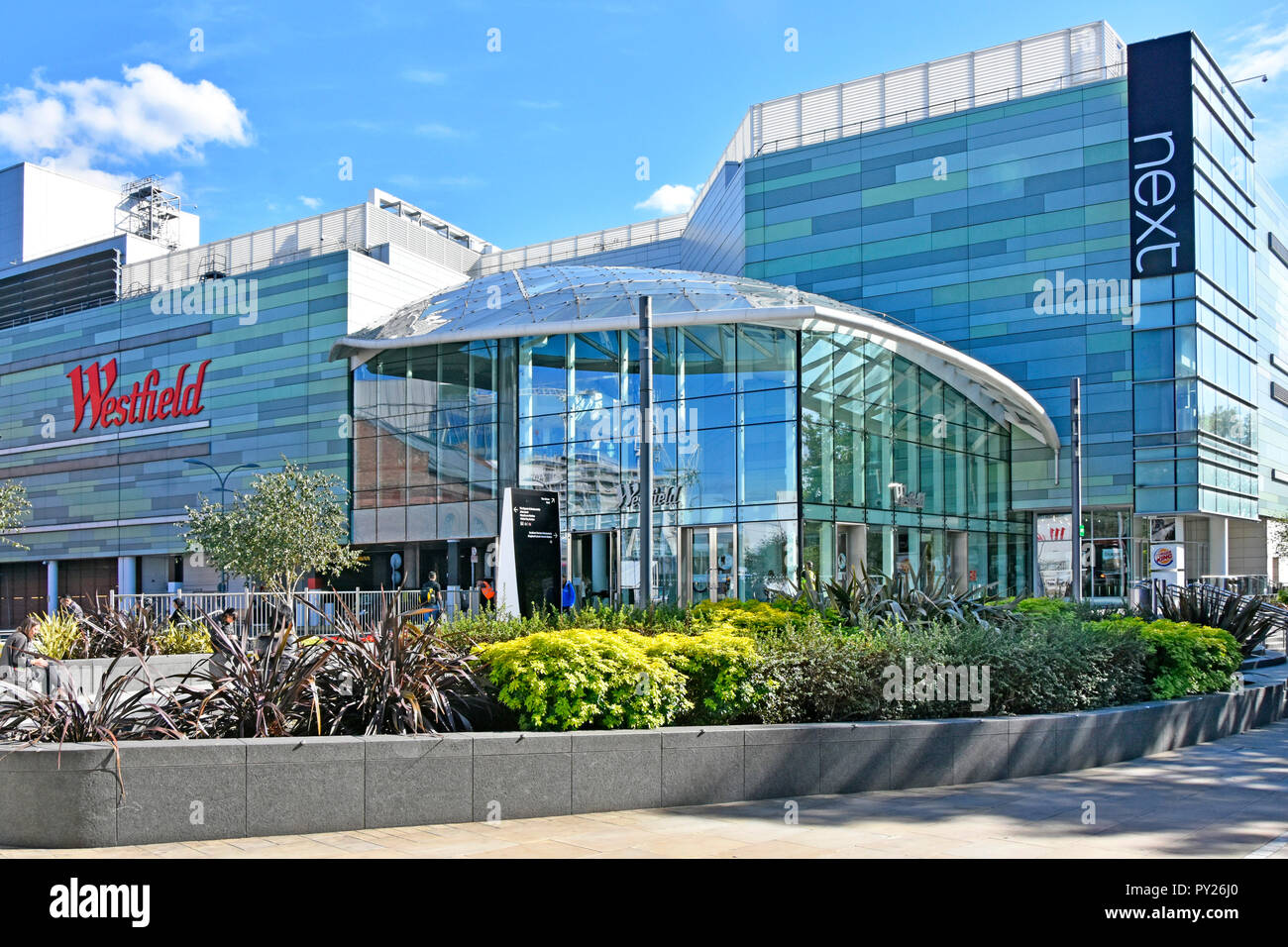 Westfield shopping di Londra Centro Città Bianca entrata di vetro edificio accanto la prossima attività di abbigliamento al dettaglio moderno design facciata ovest di Londra Inghilterra REGNO UNITO Foto Stock