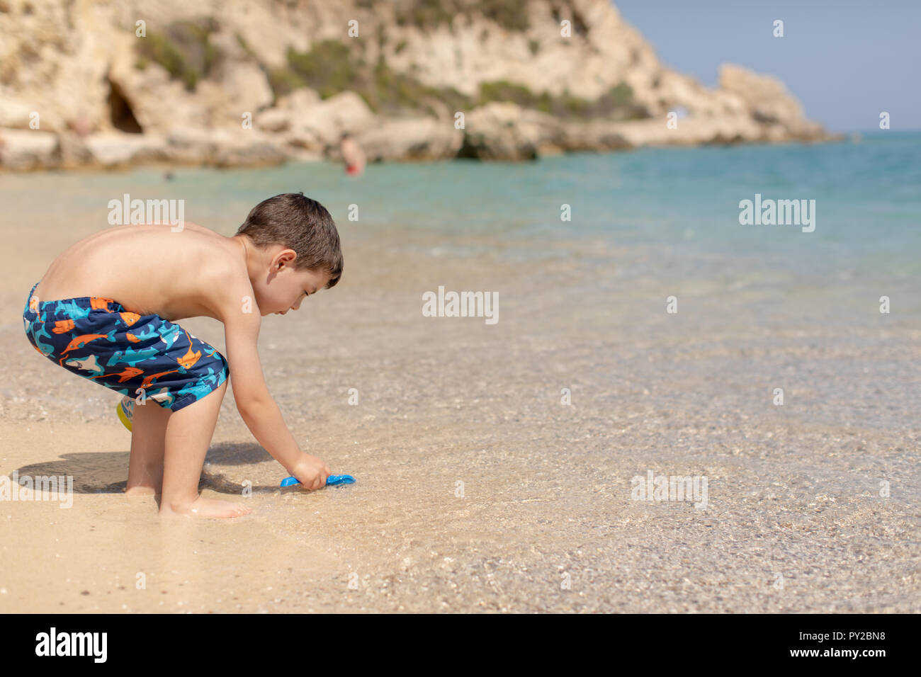 Ragazzo giocando sulla spiaggia, Grecia Foto Stock