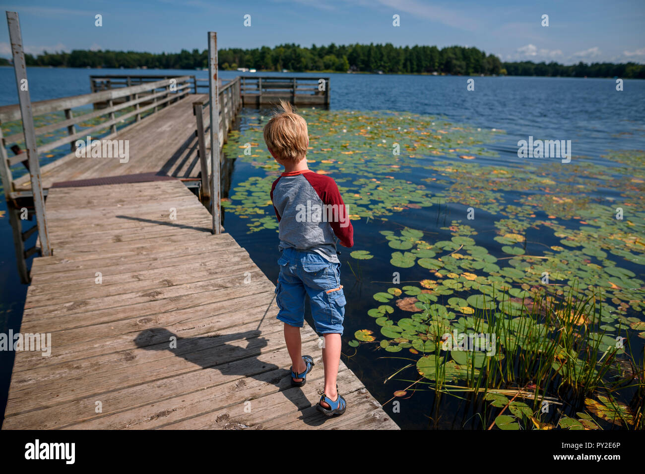 Ragazzo in piedi su un molo pesca, Stati Uniti Foto Stock