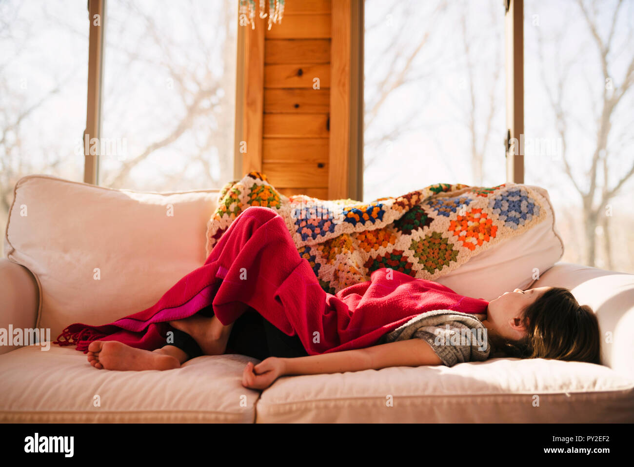 Ragazza distesa su un lettino sotto una coperta Foto Stock