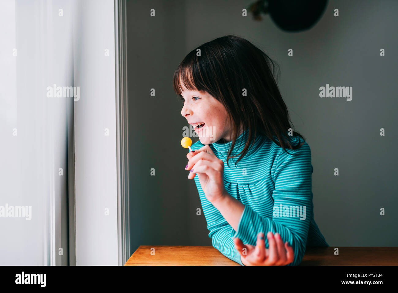 Ritratto di una ragazza sorridente con un lecca-lecca Foto Stock