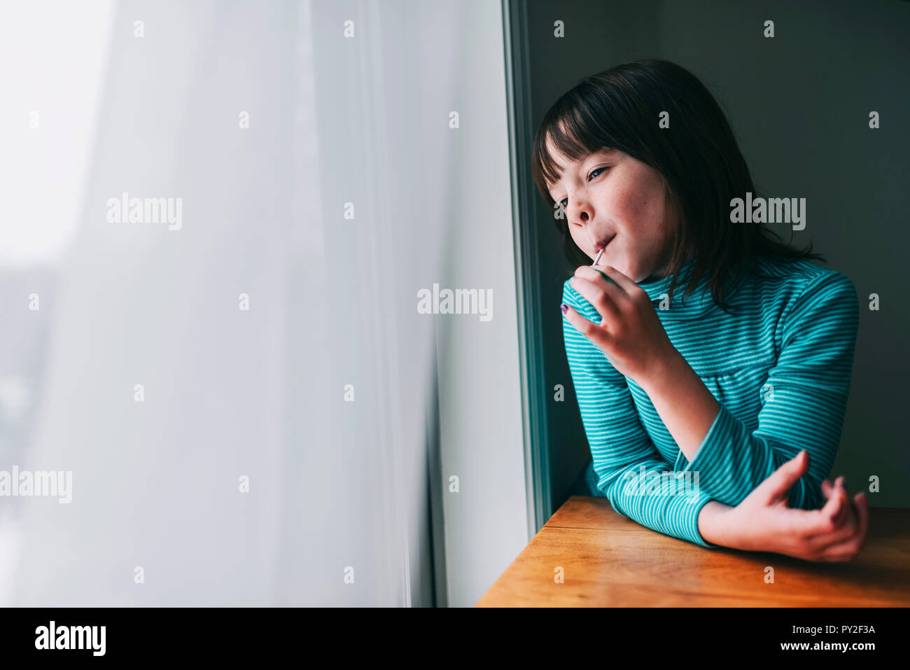 Ritratto di una ragazza sorridente di mangiare un lecca-lecca Foto Stock