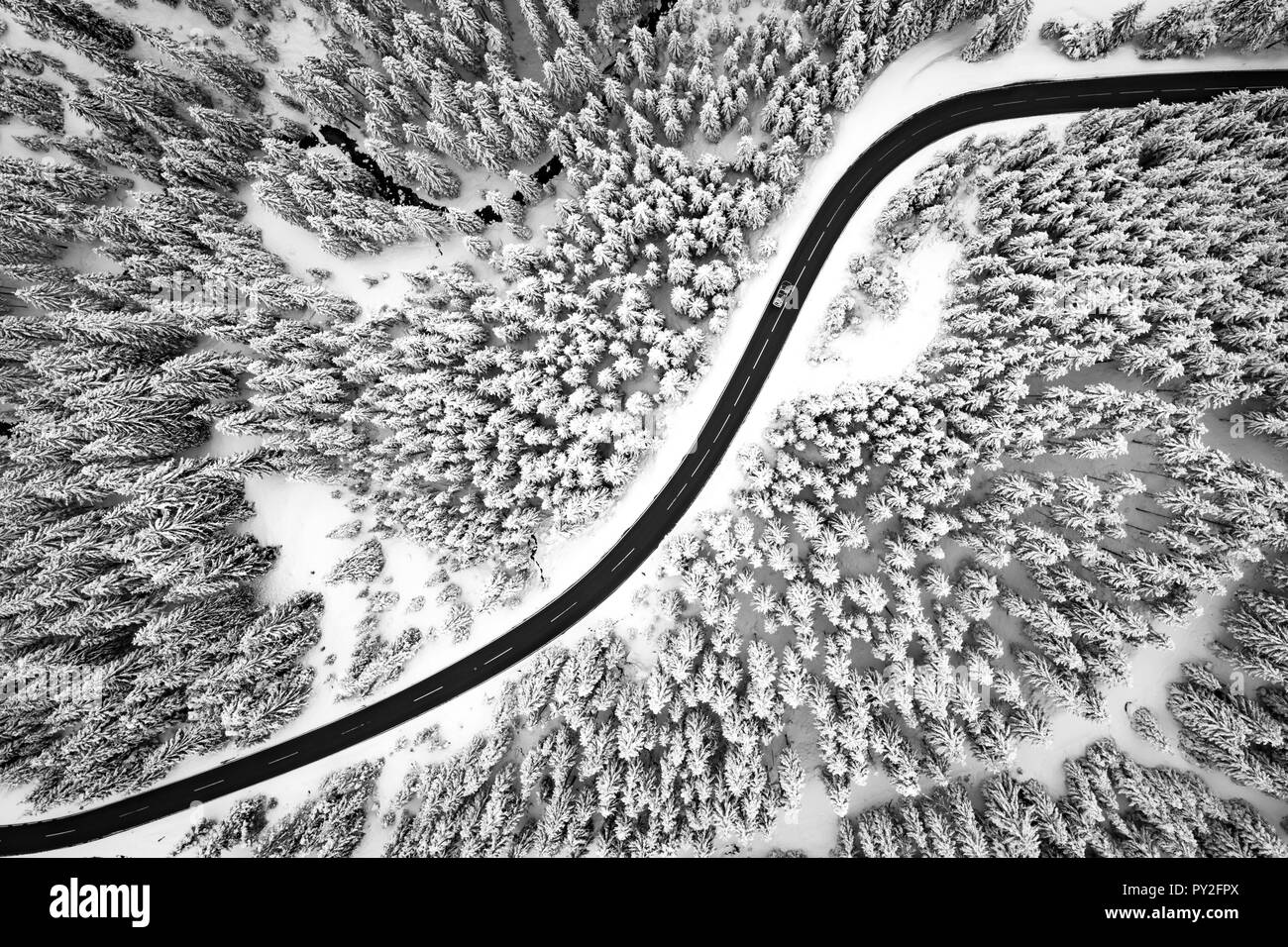 Vista aerea su un avvolgimento su strada attraverso la coperta di neve alberi, Altenmarkt, Salisburgo, Austria Foto Stock