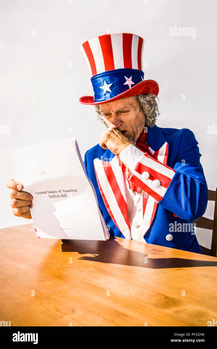 Lo zio Sam carattere guardando un rapporto di carta sul deficit USA Bill. Foto Stock