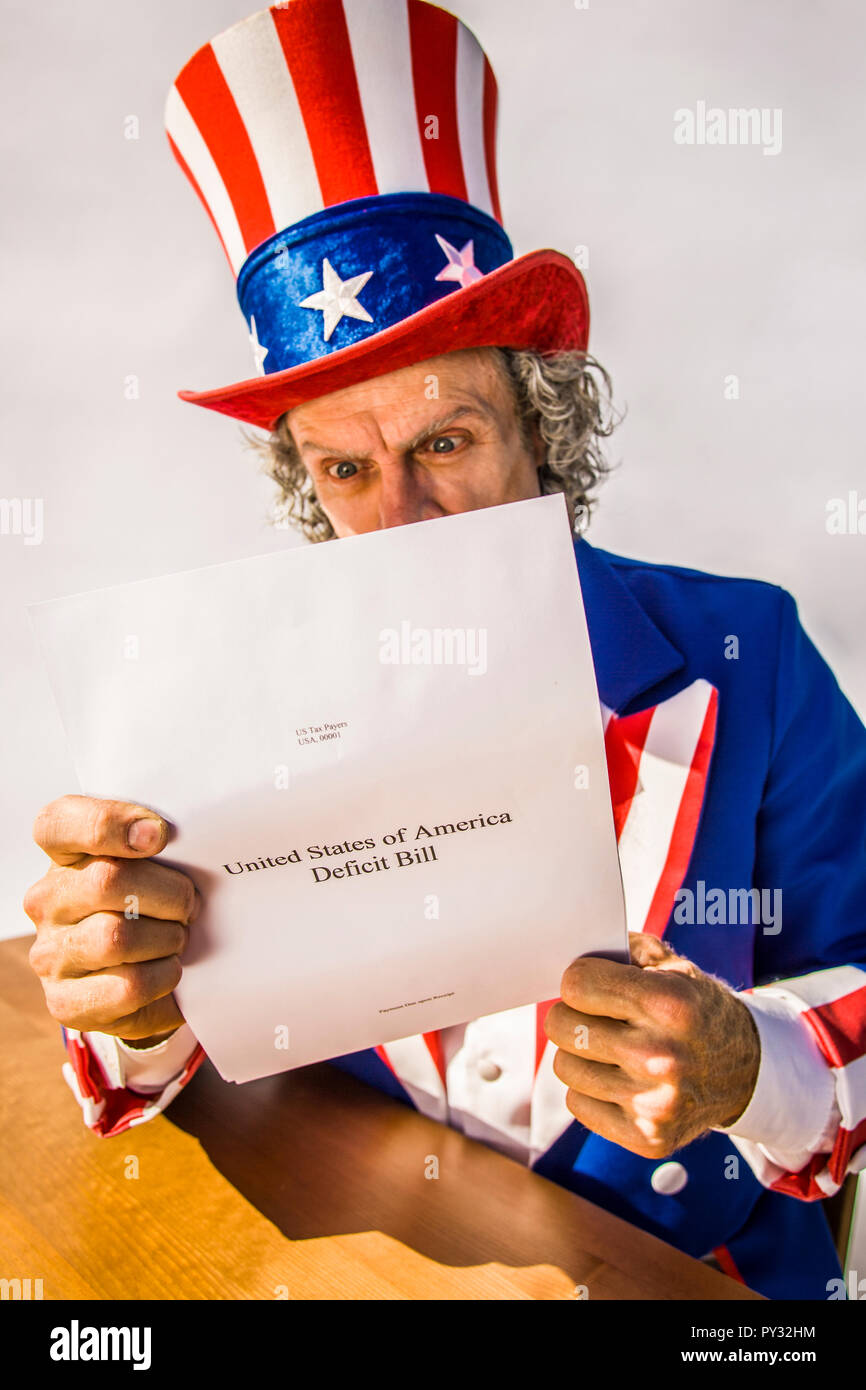 Lo zio Sam carattere guardando un rapporto di carta sul deficit USA Bill. Foto Stock