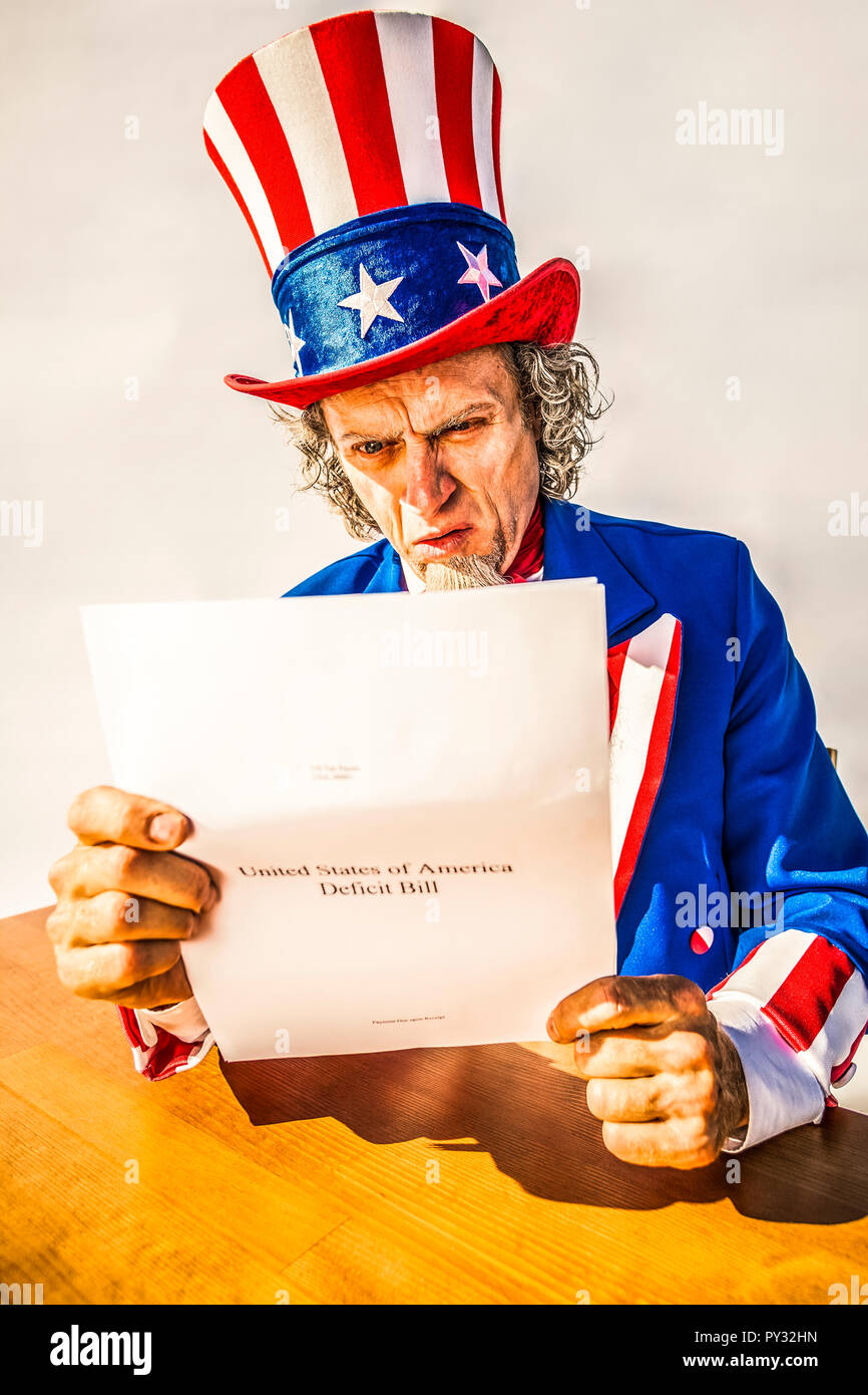Lo zio Sam carattere guardando un rapporto di carta sul deficit USA Bill. Foto Stock