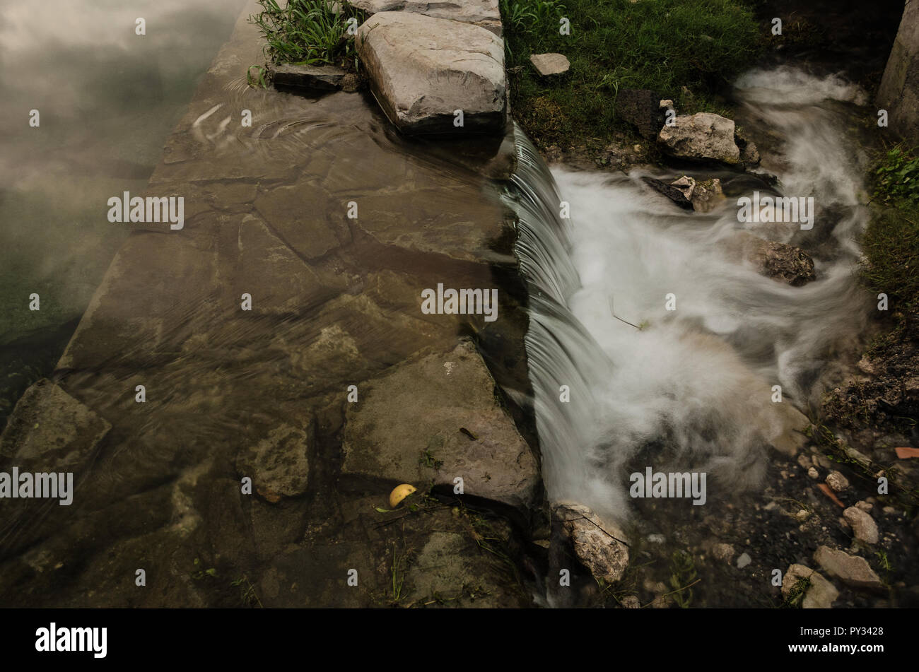 Una piccola cascata con acqua corrente, effetto seta, cascata naturale paesaggio, splendido sfondo per ispirare il viaggio. Foto Stock